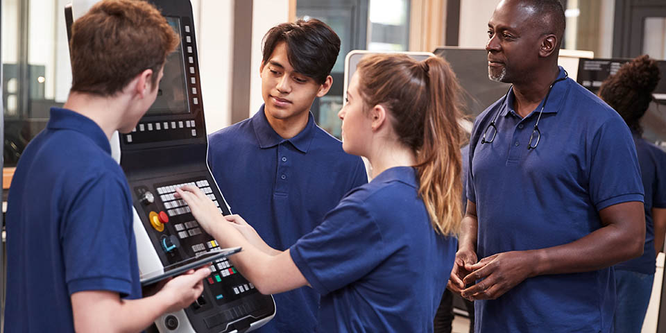 engineering apprentices with a teacher